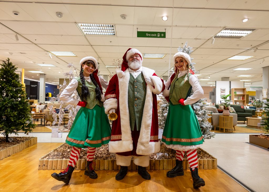 Santa Claus and his elves surrounded by colourful Christmas decorations and gifts at Eldon Square in Newcastle.