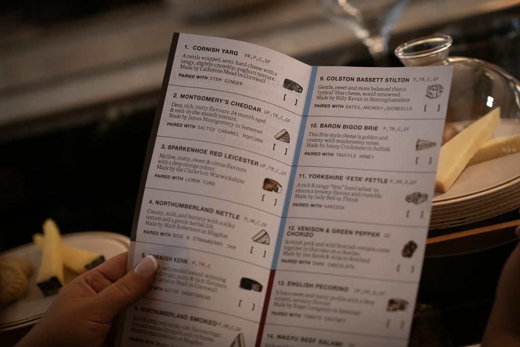 Blacks Corner cheese belt menu featuring artisan British cheeses and flavour pairings, held by a guest at Culture House in Sunderland.