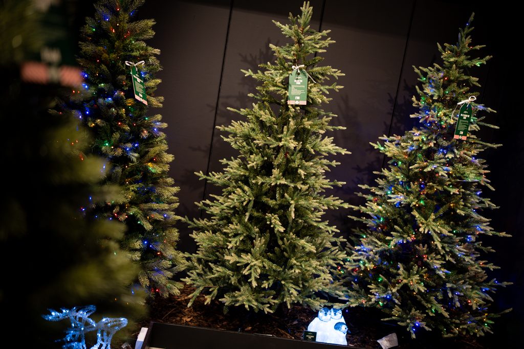 Artificial Christmas trees with colourful festive lights displayed in Fenwick Newcastle's Christmas Shop.