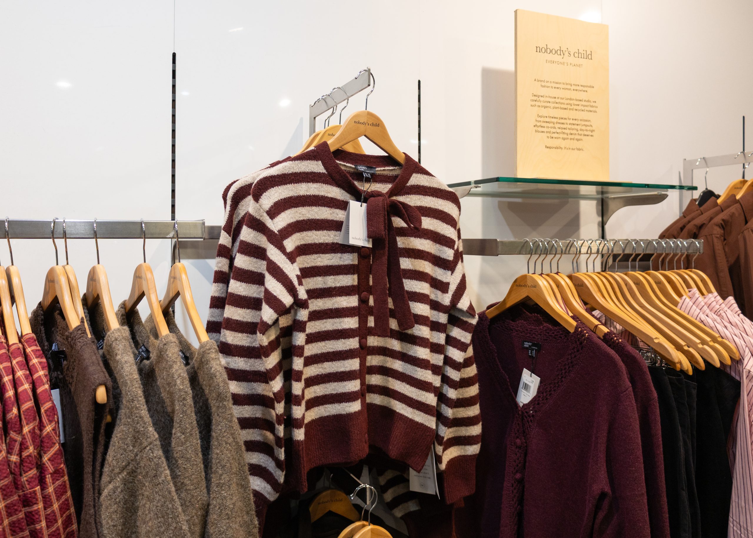 Nobody’s Child burgundy and cream striped tie-neck cardigan displayed alongside cosy autumn knitwear at John Lewis, Eldon Square.